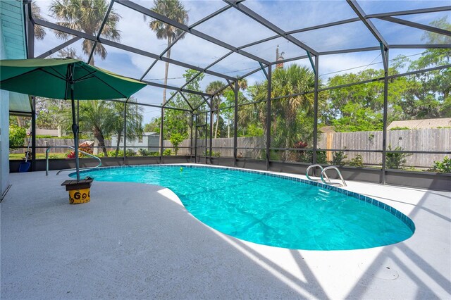 view of pool featuring a patio, a fenced in pool, a fenced backyard, and glass enclosure