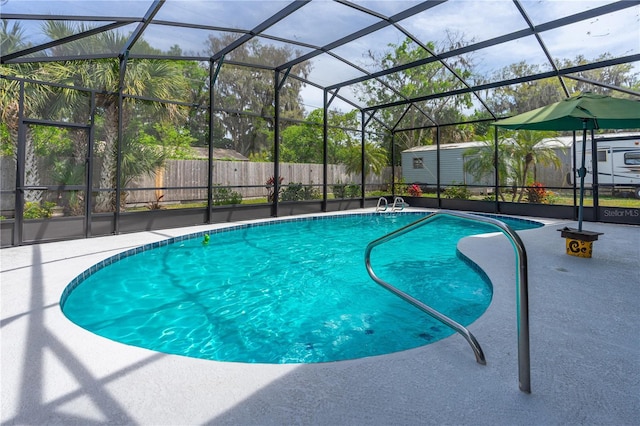view of pool featuring a lanai, a fenced in pool, a fenced backyard, a storage unit, and an outbuilding