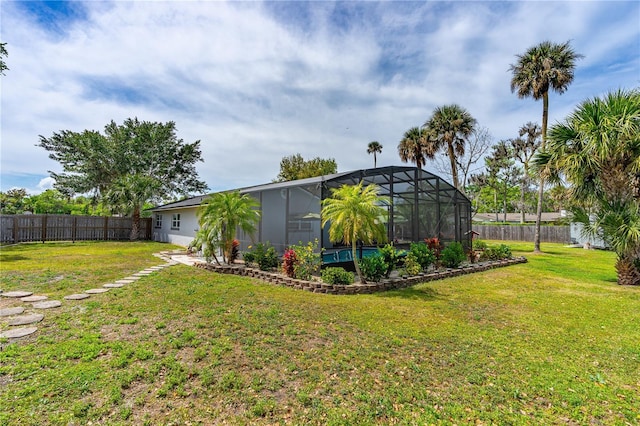 view of yard featuring a fenced backyard and a lanai