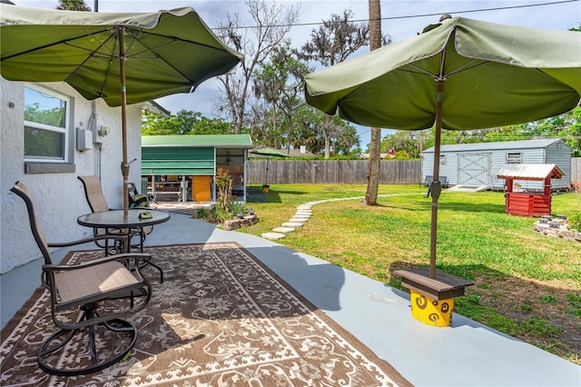 view of patio featuring a storage unit, an outdoor structure, and fence