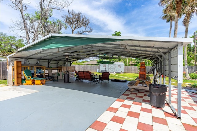 view of parking with a storage unit, a fenced backyard, and a detached carport