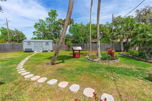 view of yard with a fenced backyard, an outbuilding, and a storage shed