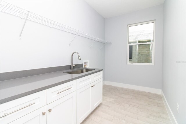 113 Douglas St, Edgewater, FL 32141 - laundry room featuring washer hookup, cabinet space, light wood-style flooring, and baseboards