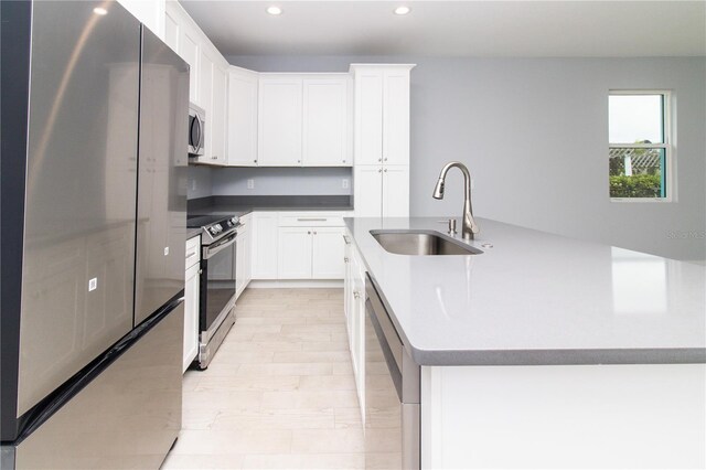 113 Douglas St, Edgewater, FL 32141 - kitchen featuring stainless steel appliances, a sink, recessed lighting, white cabinetry, and an island with sink
