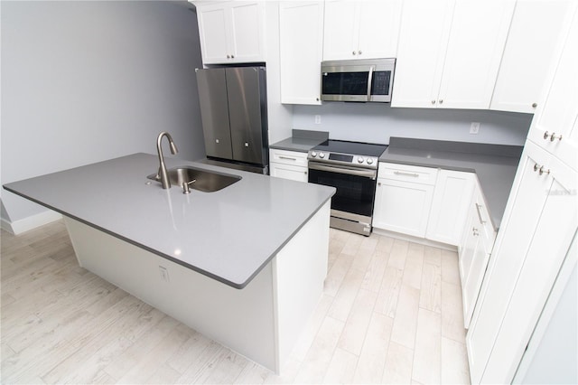 113 Douglas St, Edgewater, FL 32141 - kitchen featuring appliances with stainless steel finishes, a sink, light wood-style flooring, and white cabinetry