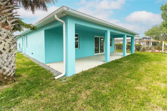 113 Douglas St, Edgewater, FL 32141 - view of property exterior featuring stucco siding, a patio, and a lawn