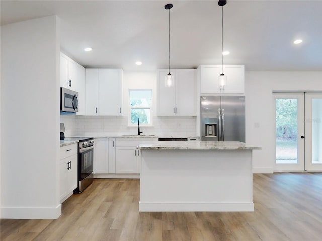 kitchen featuring decorative backsplash, a sink, stainless steel appliances, and a kitchen island