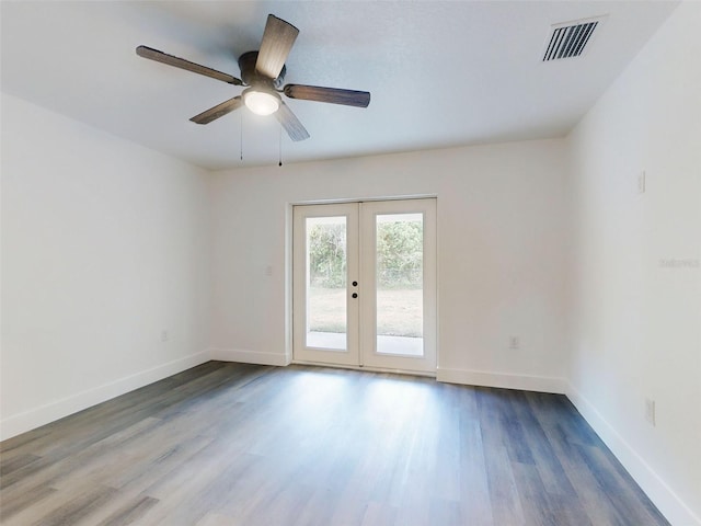unfurnished room featuring baseboards, visible vents, and wood finished floors