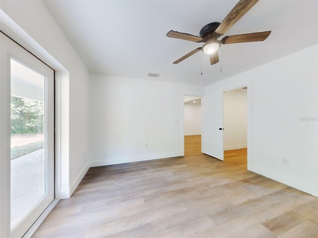 empty room with baseboards, ceiling fan, visible vents, and light wood-style floors