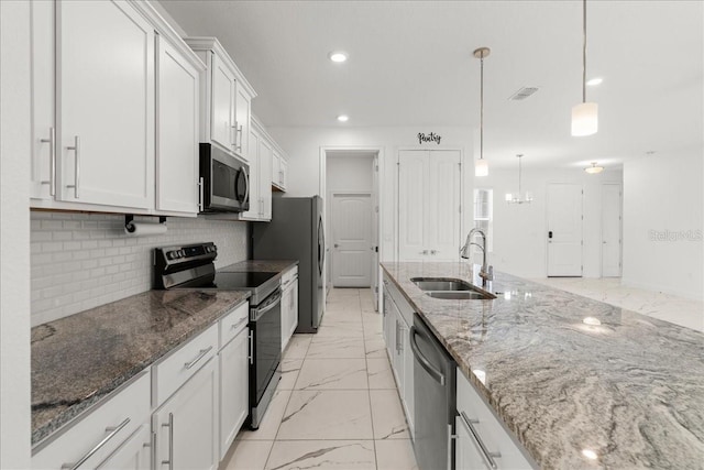 11 Lyons Pl, Palm Coast, FL 32137 - kitchen featuring stainless steel appliances, a sink, light marble finish flooring, white cabinetry, and backsplash