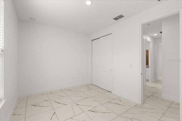 11 Lyons Pl, Palm Coast, FL 32137 - unfurnished bedroom with light marble finish floors, recessed lighting, a closet, and baseboards