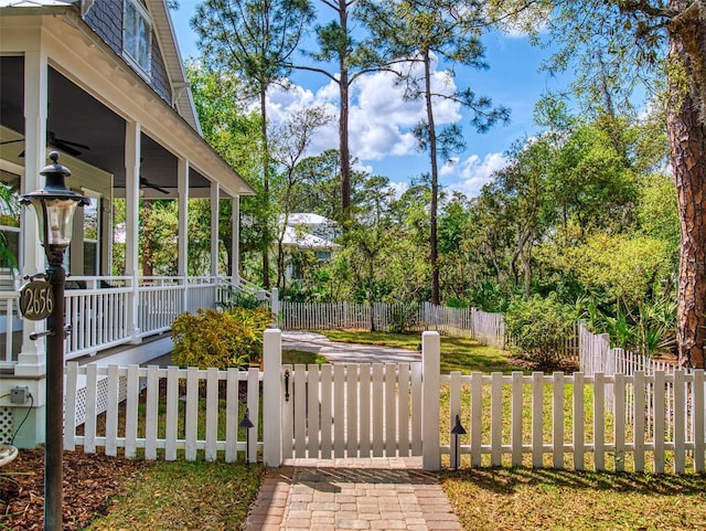 2656 Old Smyrna Trl, New Smyrna Beach, FL 32168 - view of yard featuring a gate, a fenced front yard, a porch, and ceiling fan