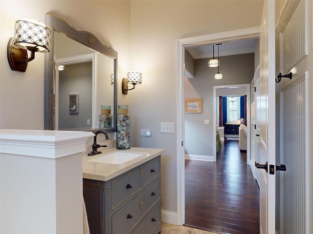 2656 Old Smyrna Trl, New Smyrna Beach, FL 32168 - bathroom featuring baseboards, wood finished floors, ornamental molding, and vanity