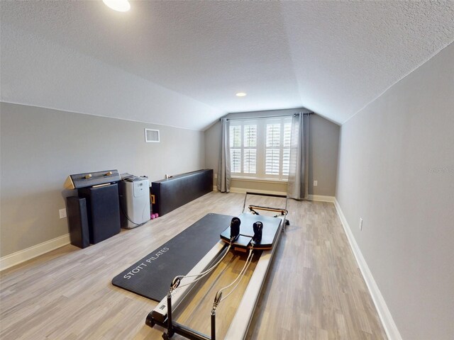 2656 Old Smyrna Trl, New Smyrna Beach, FL 32168 - exercise area featuring lofted ceiling, baseboards, a textured ceiling, light wood finished floors, and visible vents