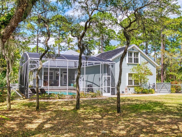 2656 Old Smyrna Trl, New Smyrna Beach, FL 32168 - rear view of property with glass enclosure, a yard, and an outdoor pool