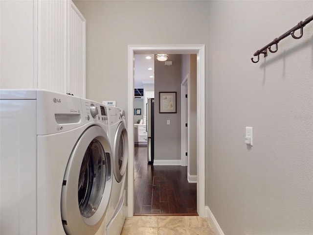 2656 Old Smyrna Trl, New Smyrna Beach, FL 32168 - washroom with washing machine and clothes dryer, cabinet space, baseboards, and wood finished floors