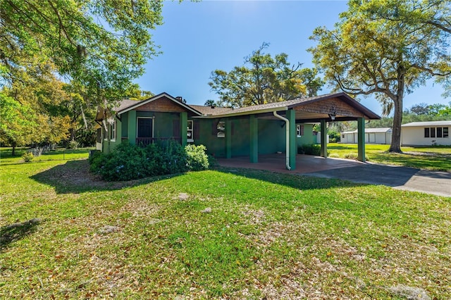 191 Howes St, Oak Hill, FL 32759 - view of front of property featuring a front lawn, an attached carport, driveway, and stucco siding