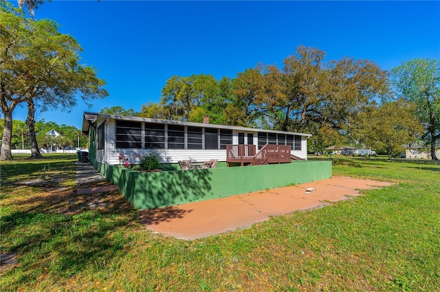 191 Howes St, Oak Hill, FL 32759 - back of property with a yard, a wooden deck, and a sunroom