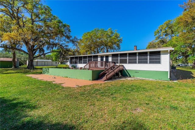 191 Howes St, Oak Hill, FL 32759 - rear view of property featuring stairway, a sunroom, and a lawn