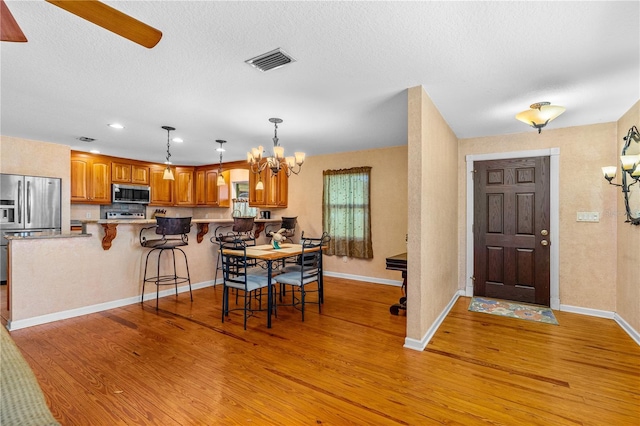 191 Howes St, Oak Hill, FL 32759 - dining room featuring light wood-style floors, visible vents, baseboards, and ceiling fan with notable chandelier