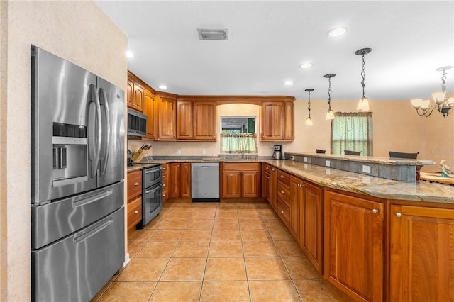 191 Howes St, Oak Hill, FL 32759 - kitchen featuring visible vents, light tile patterned floors, appliances with stainless steel finishes, a peninsula, and brown cabinets