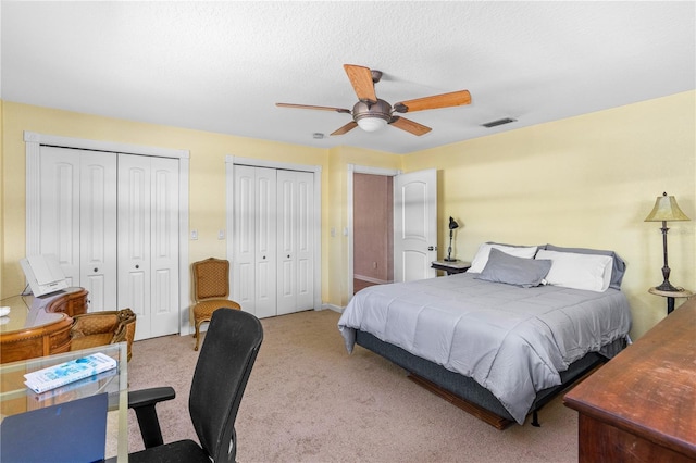 191 Howes St, Oak Hill, FL 32759 - bedroom with a textured ceiling, a ceiling fan, carpet floors, visible vents, and multiple closets