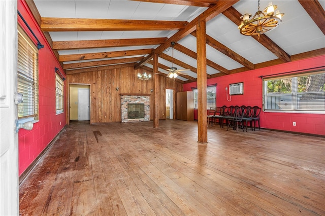 191 Howes St, Oak Hill, FL 32759 - unfurnished living room featuring a wall mounted AC, a fireplace, concrete block wall, wood-type flooring, and vaulted ceiling with beams