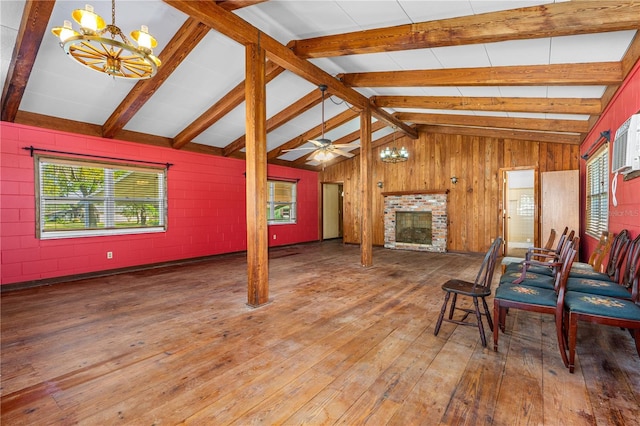 191 Howes St, Oak Hill, FL 32759 - living area featuring a brick fireplace, wooden walls, concrete block wall, vaulted ceiling with beams, and hardwood / wood-style floors