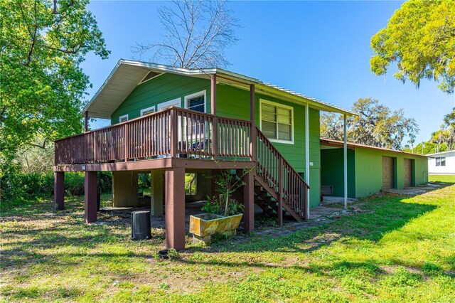 191 Howes St, Oak Hill, FL 32759 - rear view of house featuring stairs, a deck, and a lawn