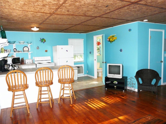 191 Howes St, Oak Hill, FL 32759 - kitchen featuring a wall mounted air conditioner, white appliances, open shelves, a kitchen bar, and hardwood / wood-style flooring