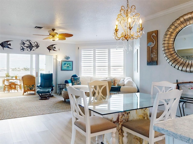 438 Bouchelle Dr Unit 104, New Smyrna Beach, FL 32169 - dining space with crown molding, ceiling fan with notable chandelier, a textured ceiling, visible vents, and wood finished floors