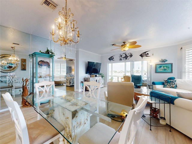 438 Bouchelle Dr Unit 104, New Smyrna Beach, FL 32169 - dining area with ceiling fan with notable chandelier, visible vents, crown molding, and wood finished floors
