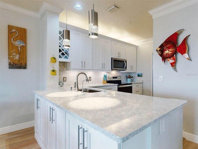 438 Bouchelle Dr Unit 104, New Smyrna Beach, FL 32169 - kitchen featuring crown molding, stainless steel appliances, decorative backsplash, a sink, and visible vents