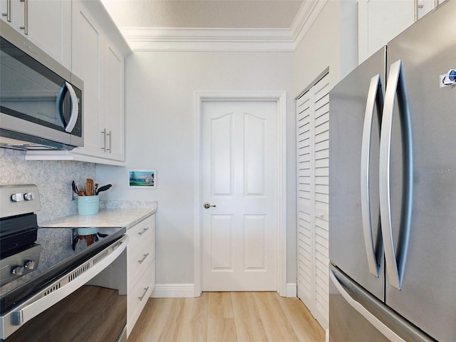 438 Bouchelle Dr Unit 104, New Smyrna Beach, FL 32169 - kitchen with light countertops, crown molding, appliances with stainless steel finishes, white cabinetry, and backsplash