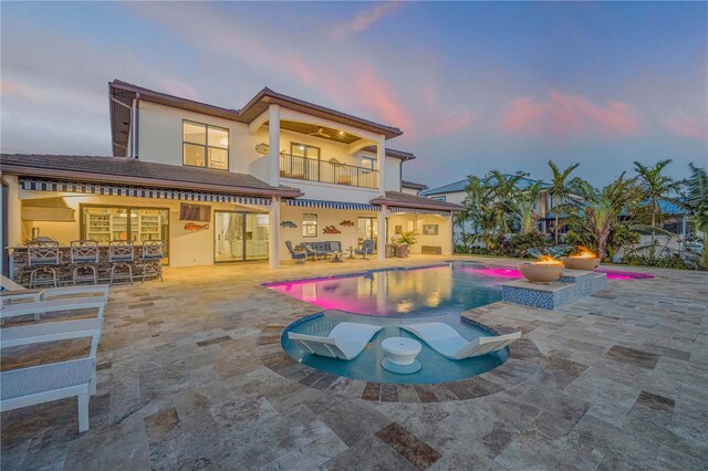 1212 Commodore Dr, New Smyrna Beach, FL 32168 - rear view of house with an outdoor pool, a patio, a balcony, and a jacuzzi