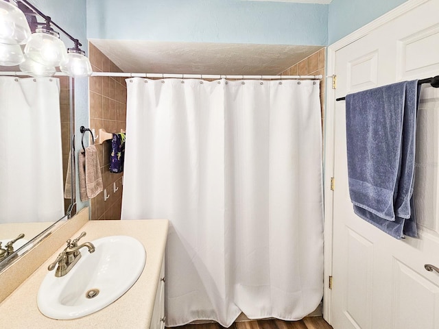 bathroom with vanity, a shower with curtain, and a textured ceiling