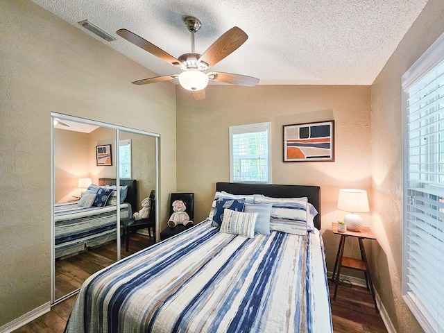 bedroom with a textured ceiling, wood finished floors, lofted ceiling, and visible vents