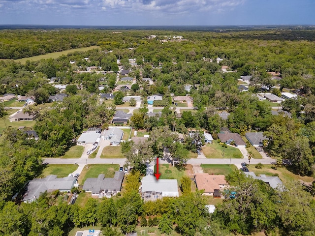 drone / aerial view featuring a wooded view and a residential view