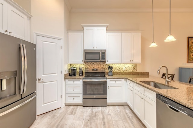 3331 Torre Blvd, New Smyrna Beach, FL 32168 - kitchen featuring crown molding, white cabinets, tasteful backsplash, a sink, and stainless steel appliances
