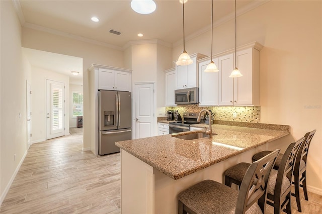3331 Torre Blvd, New Smyrna Beach, FL 32168 - kitchen with visible vents, crown molding, appliances with stainless steel finishes, light stone countertops, and a sink