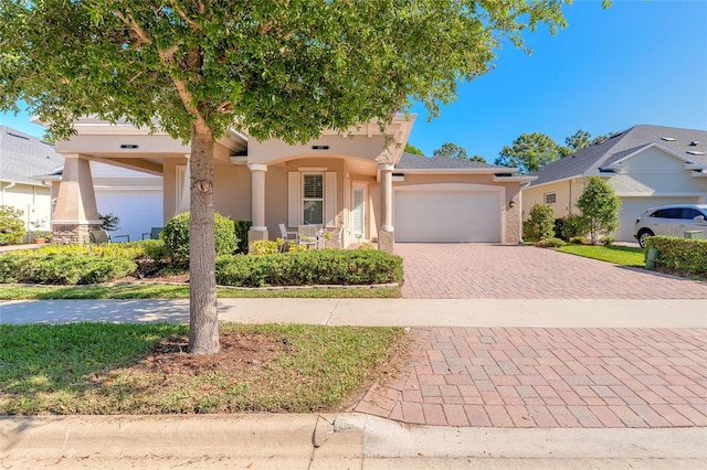 3331 Torre Blvd, New Smyrna Beach, FL 32168 - view of front of house with an attached garage, decorative driveway, and stucco siding