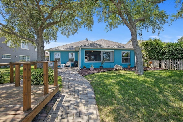 view of front of home featuring fence, a front yard, and stucco siding