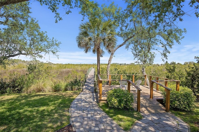 view of home's community with a view of trees and a lawn