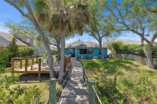 view of front of property featuring fence, a front yard, and a deck