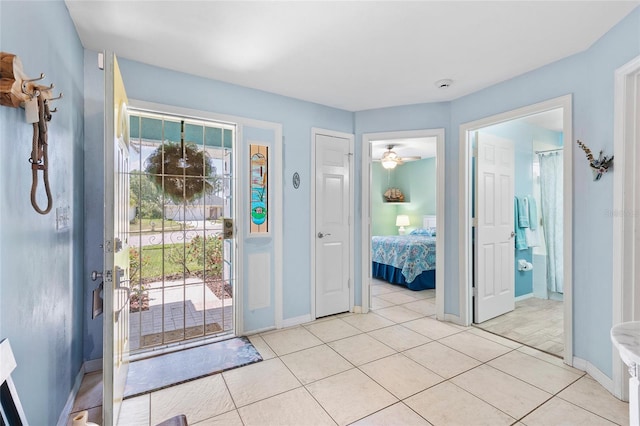 entrance foyer featuring baseboards, ceiling fan, and light tile patterned floors