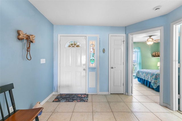 entryway featuring ceiling fan, baseboards, and light tile patterned floors