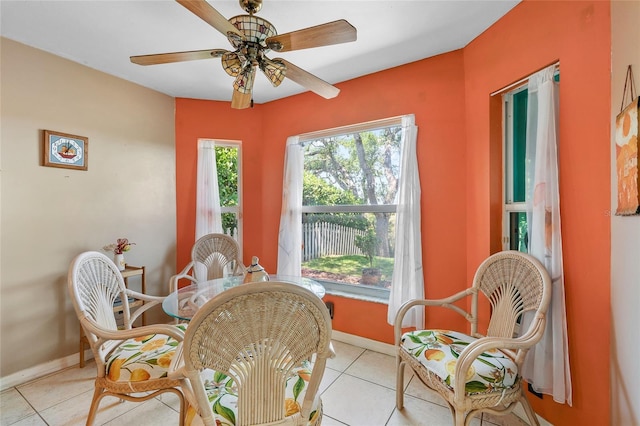 dining area featuring baseboards, a ceiling fan, and light tile patterned floors
