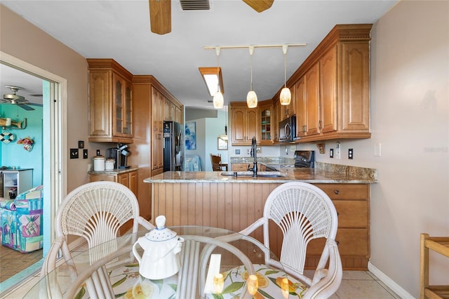 kitchen featuring ceiling fan, brown cabinets, a peninsula, and black appliances