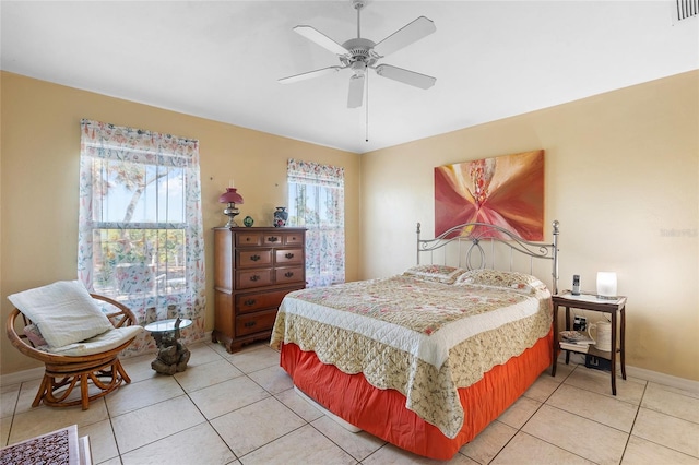 bedroom with visible vents, a ceiling fan, baseboards, and light tile patterned floors