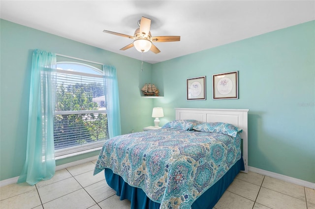 tiled bedroom featuring baseboards and a ceiling fan